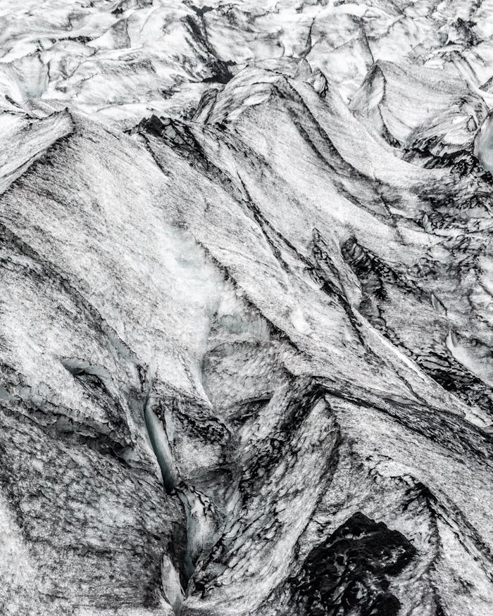 A detailed aerial shot of glacial ice and rock formations showcasing natural textures.